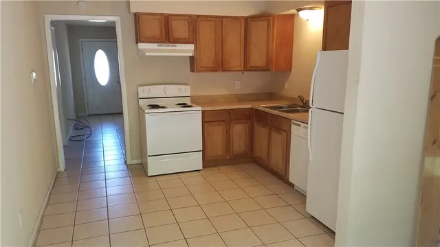 a kitchen with a stove a refrigerator and cabinets