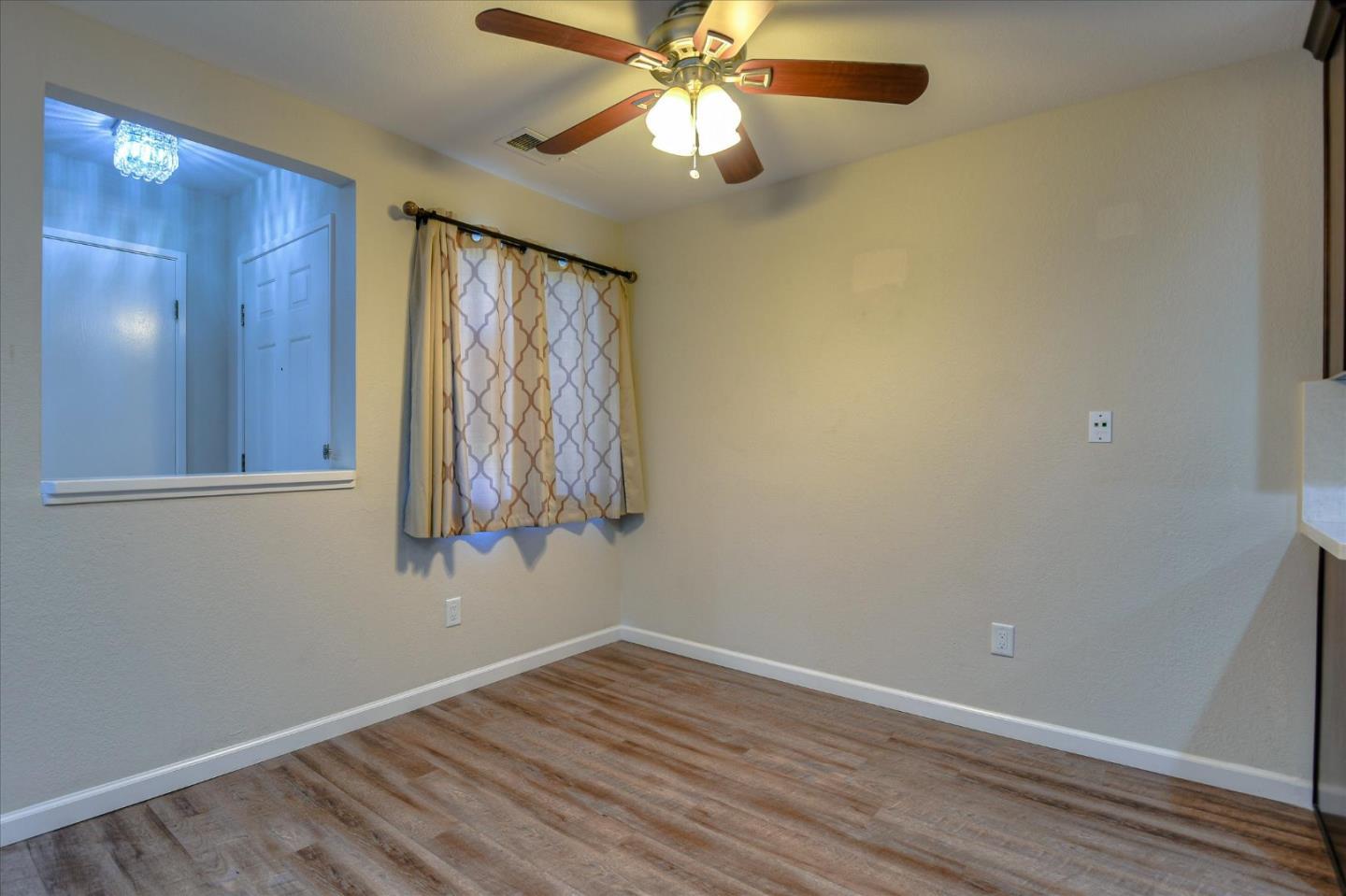 46948 Shale Common, Unit 112 Fremont, CA 94539 - Photo 13 of 30 a view of an empty room with window and chandelier fan