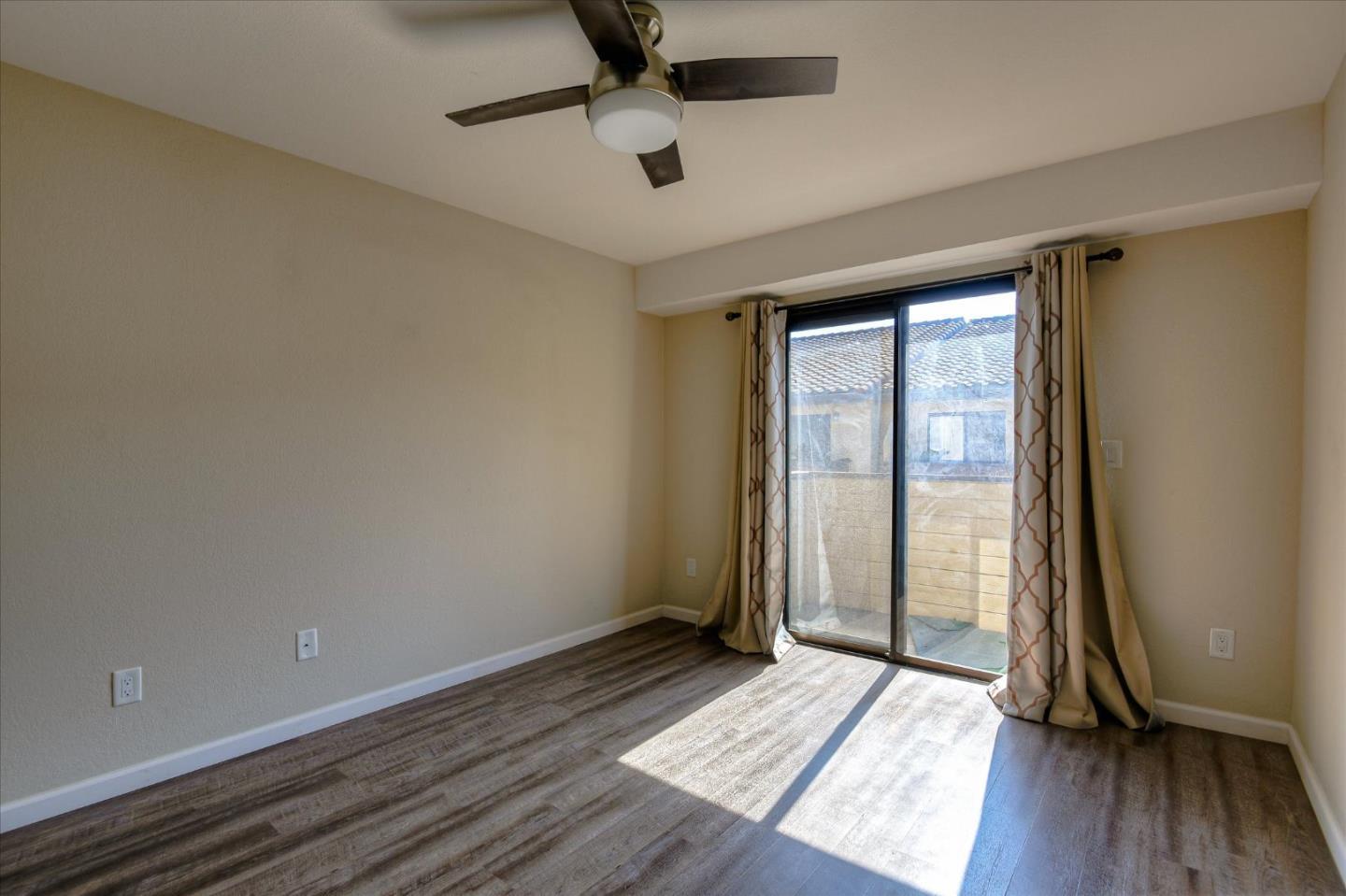 46948 Shale Common, Unit 112 Fremont, CA 94539 - Photo 22 of 30 an empty room with wooden floor and windows