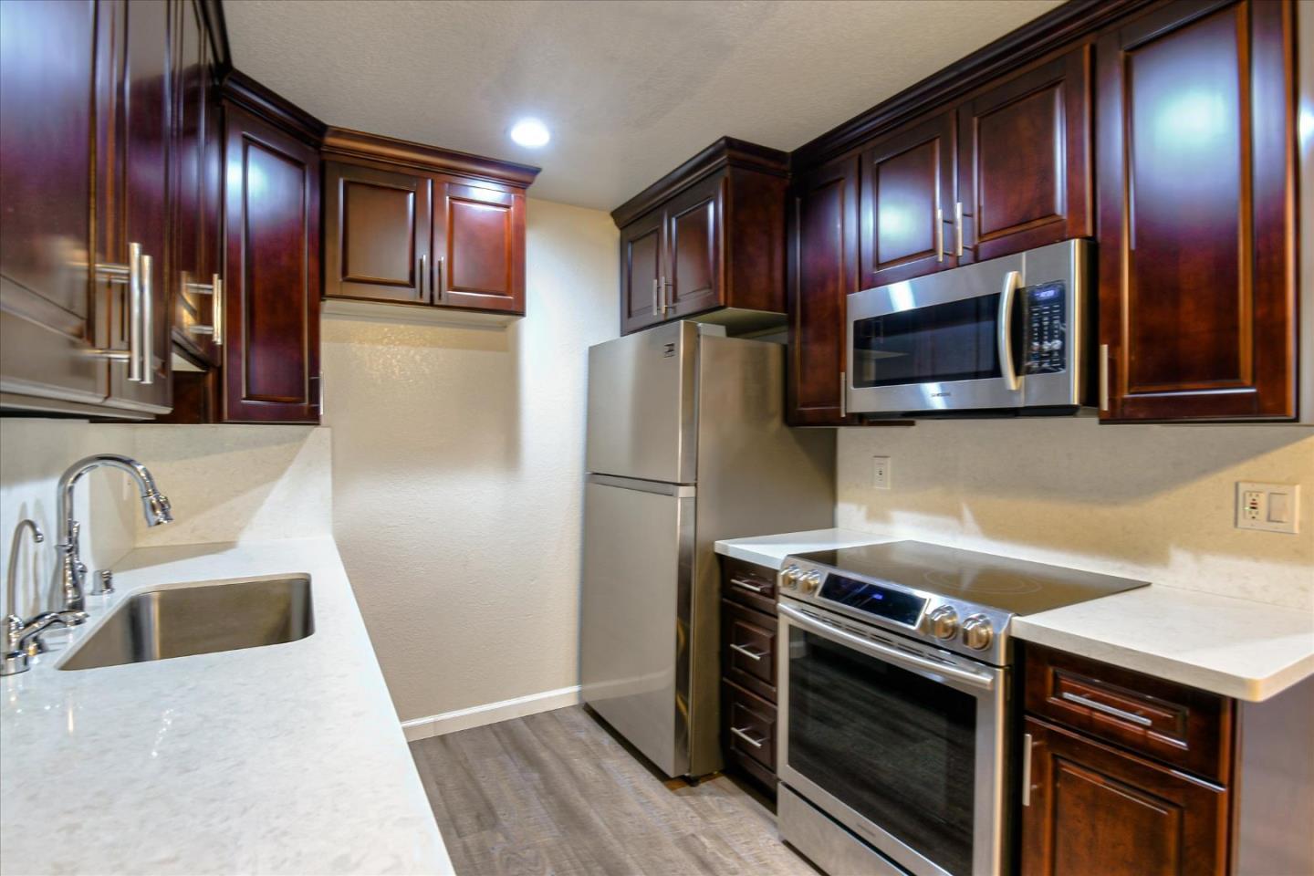 46948 Shale Common, Unit 112 Fremont, CA 94539 - Photo 3 of 30 a kitchen with granite countertop stainless steel appliances and wooden cabinets