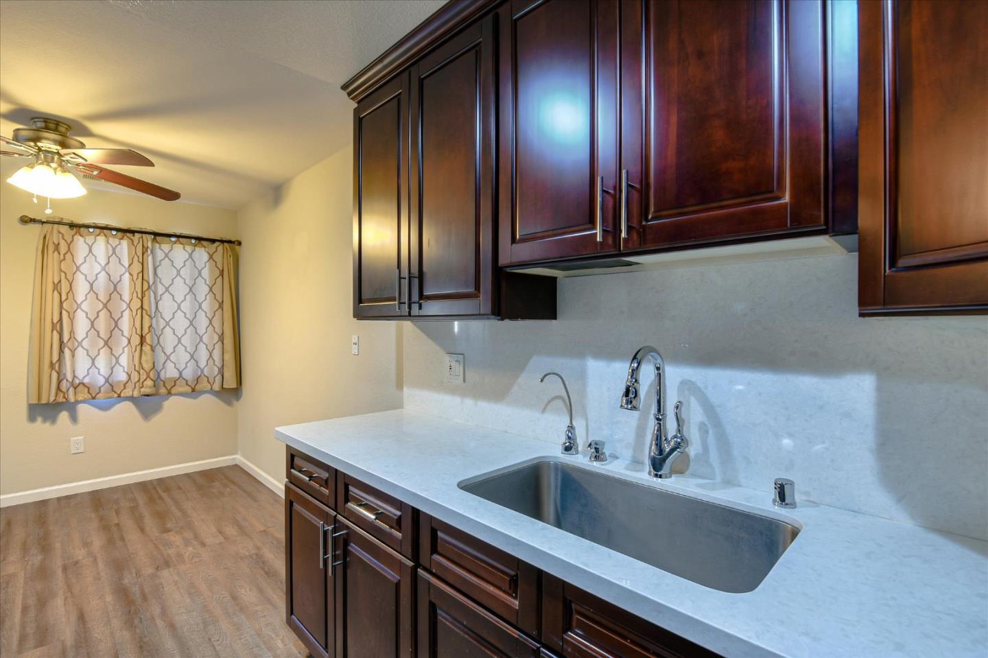 46948 Shale Common, Unit 112 Fremont, CA 94539 - Photo 4 of 30 a view of a sink and dishwasher with wooden cabinet
