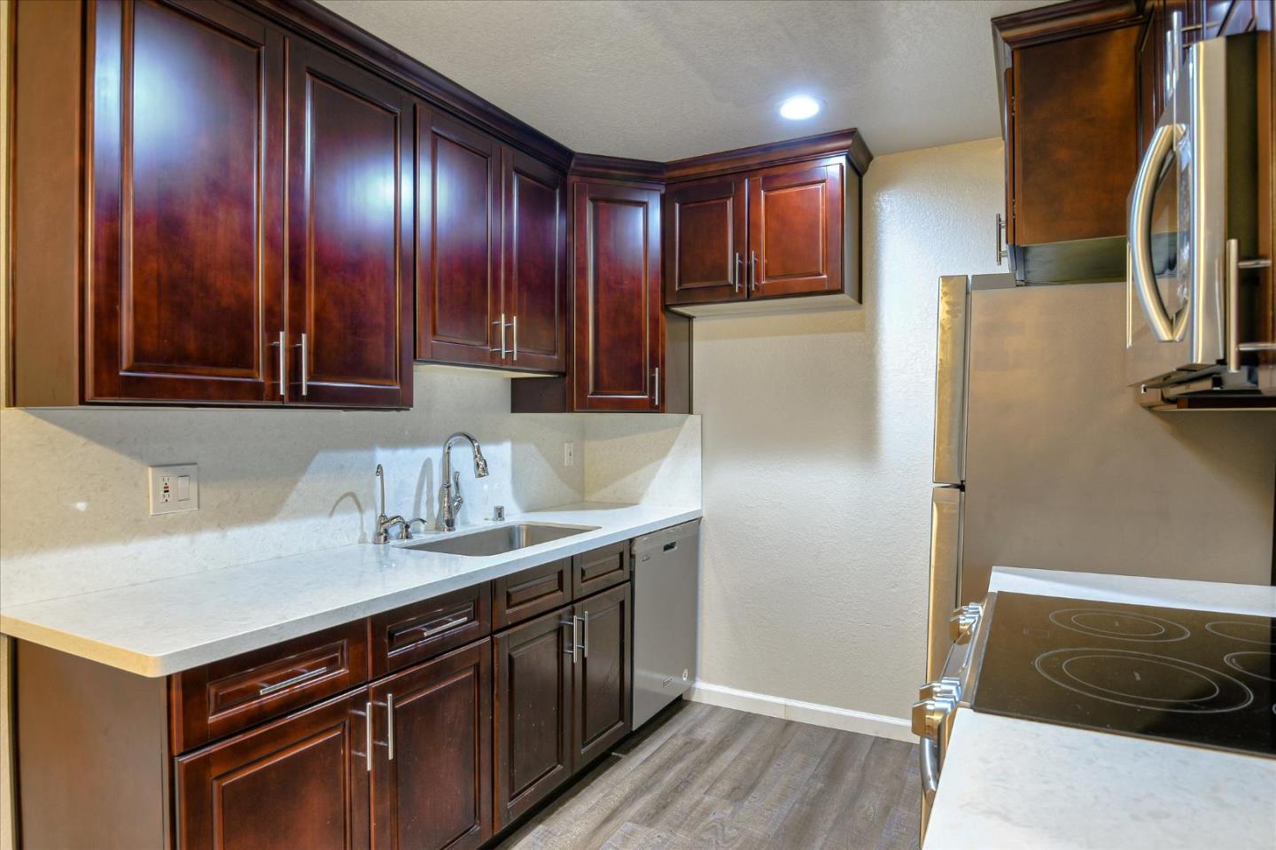 46948 Shale Common, Unit 112 Fremont, CA 94539 - Photo 5 of 30 a kitchen with stainless steel appliances granite countertop a refrigerator a sink and wooden cabinets