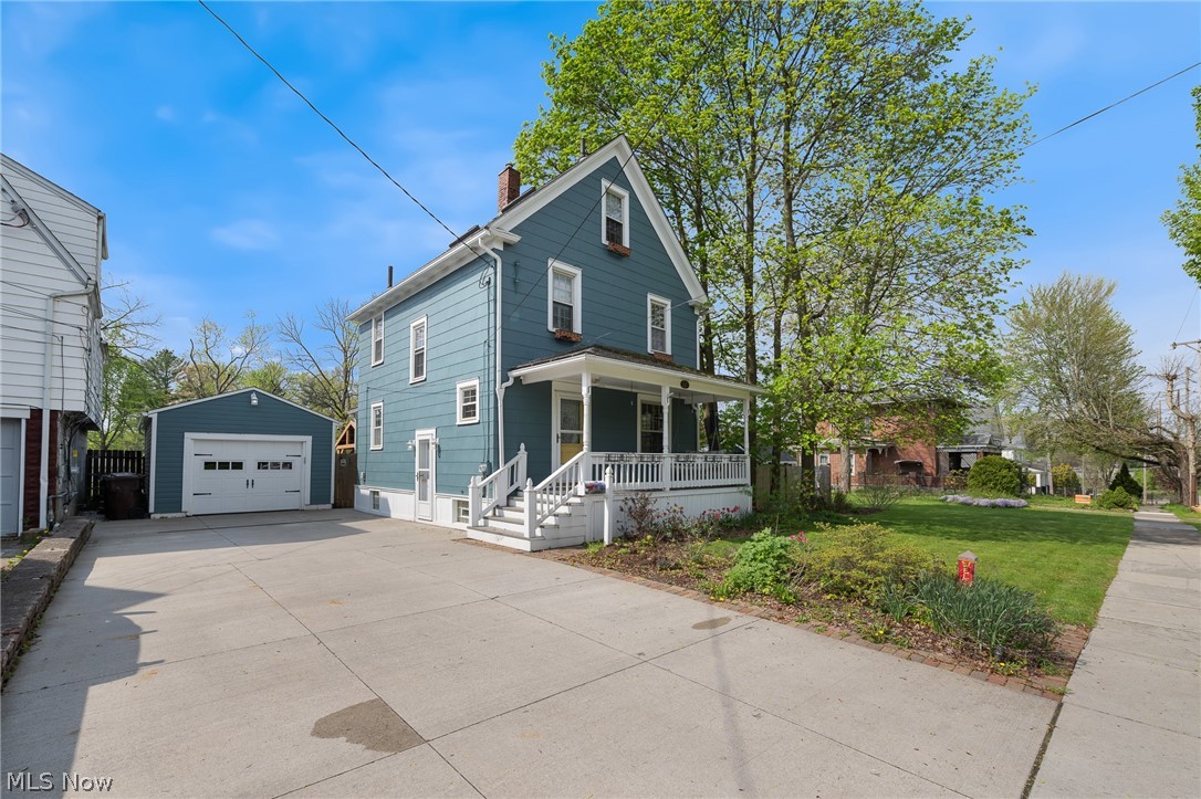Front of property with a garage, a front lawn, covered porch