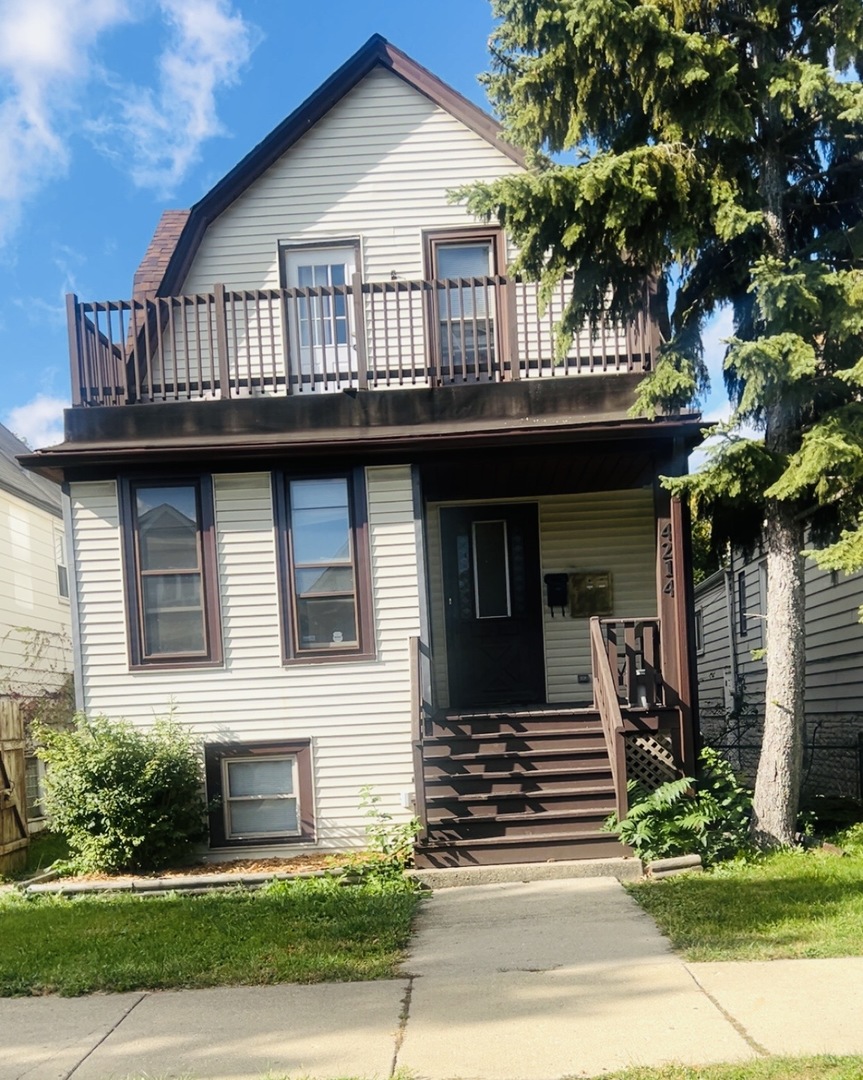 a front view of a house with a tree