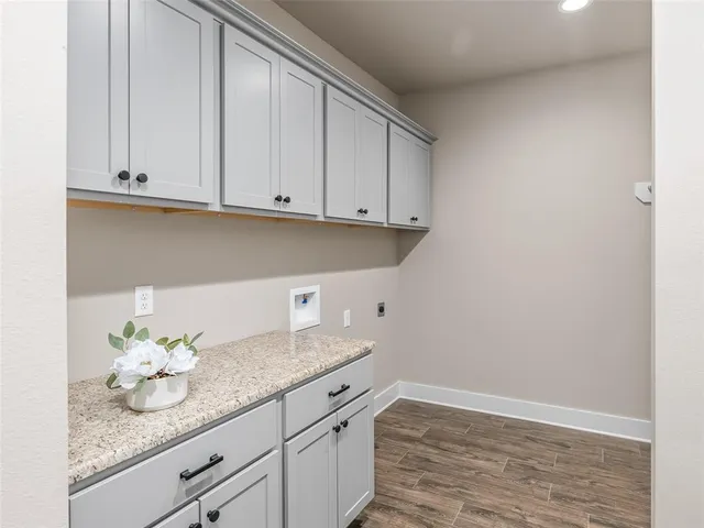 a kitchen with granite countertop white cabinets and a sink