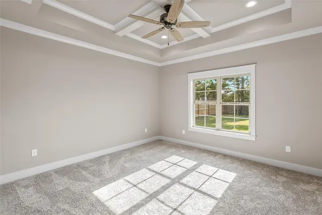 an empty room with windows and ceiling fan
