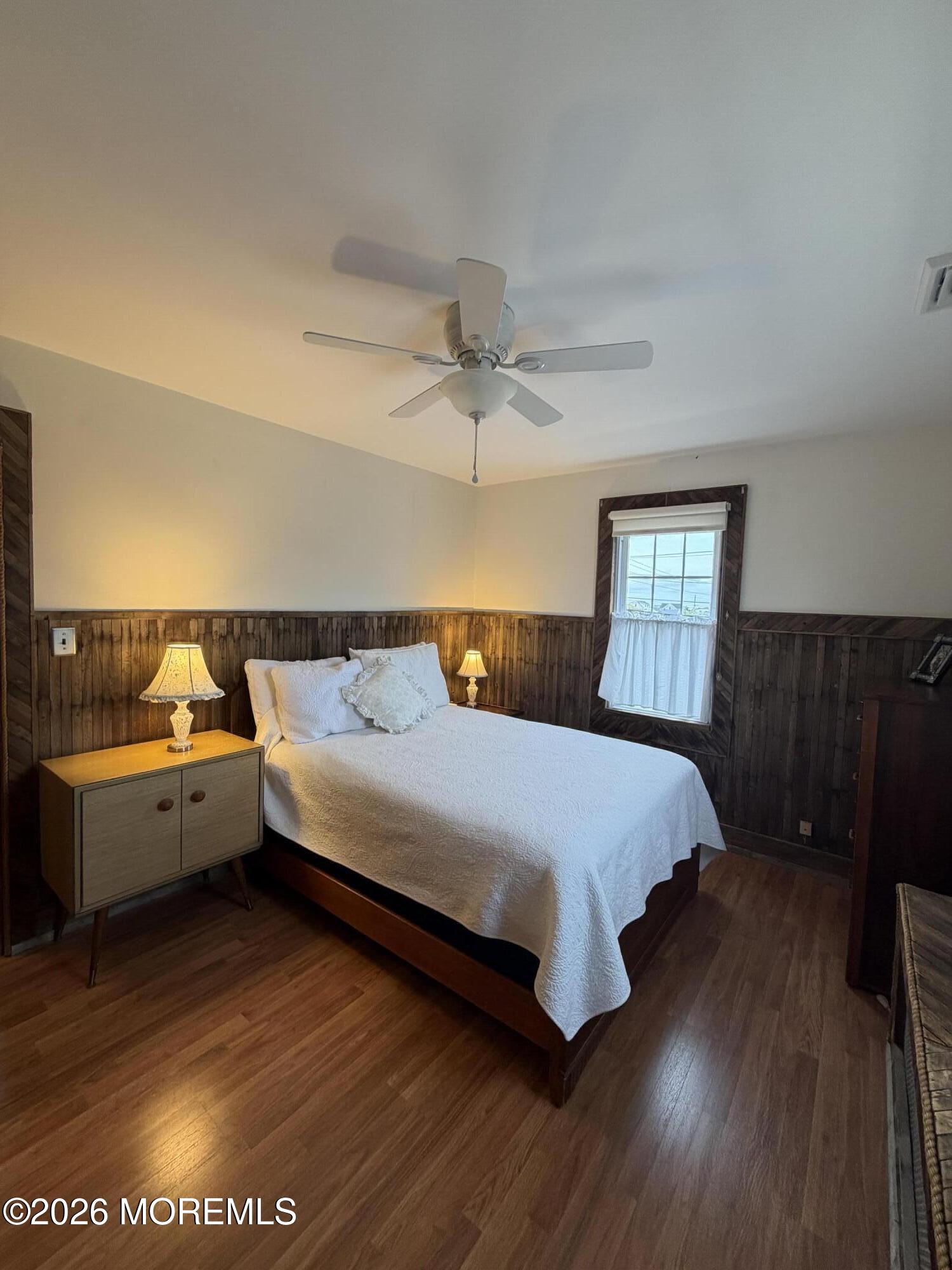 67 E Street Seaside Park, NJ 08752 - Photo 19 of 26 a bed sitting in a bedroom next to a window with a chandelier