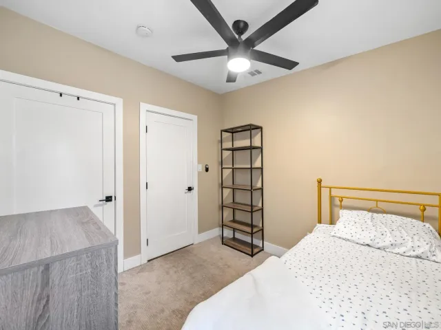 a bedroom with a large bed and a chandelier