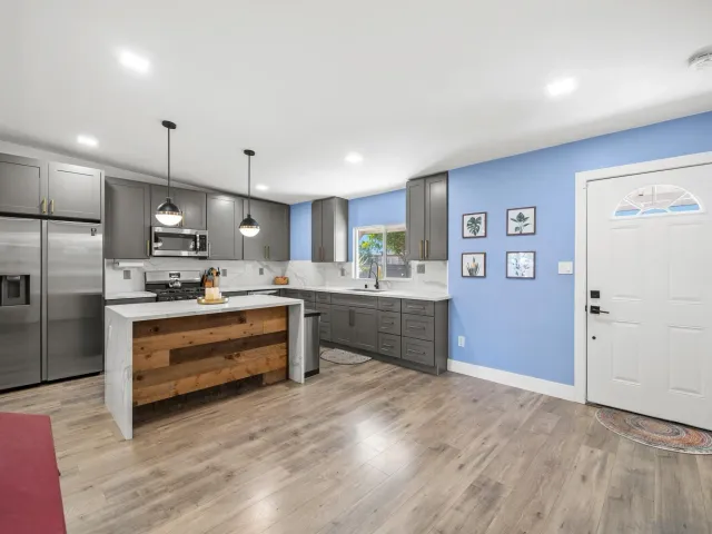 a large kitchen with kitchen island a sink stainless steel appliances and cabinets