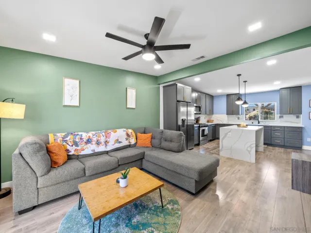 a living room with furniture and kitchen view