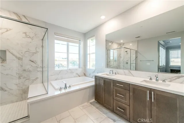 a bathroom with a bathtub double vanity sink and mirror