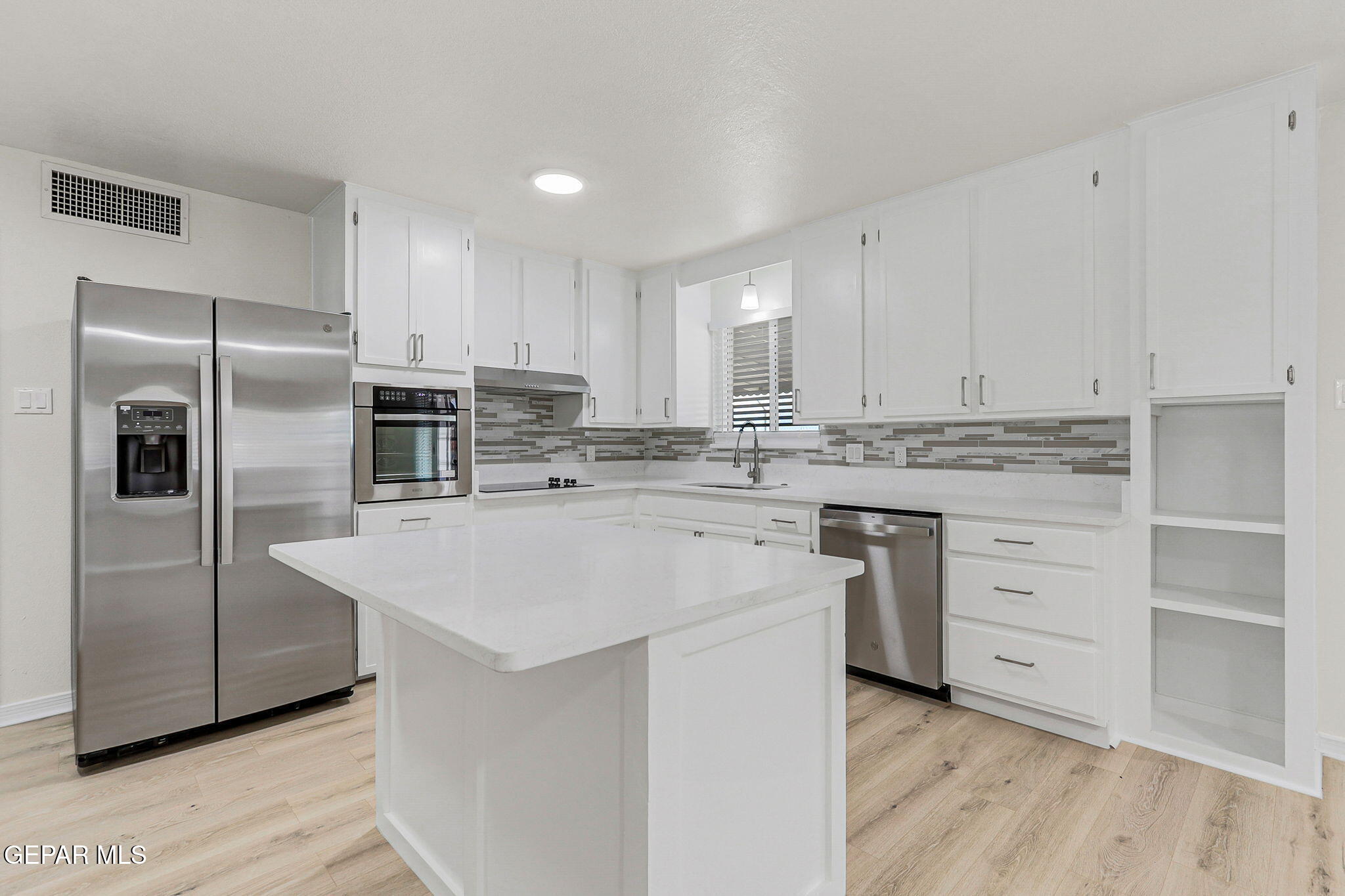 309 Clairemont Road El Paso, TX 79912 - Photo 12 of 40 a kitchen with stainless steel appliances granite countertop a refrigerator sink and white cabinets