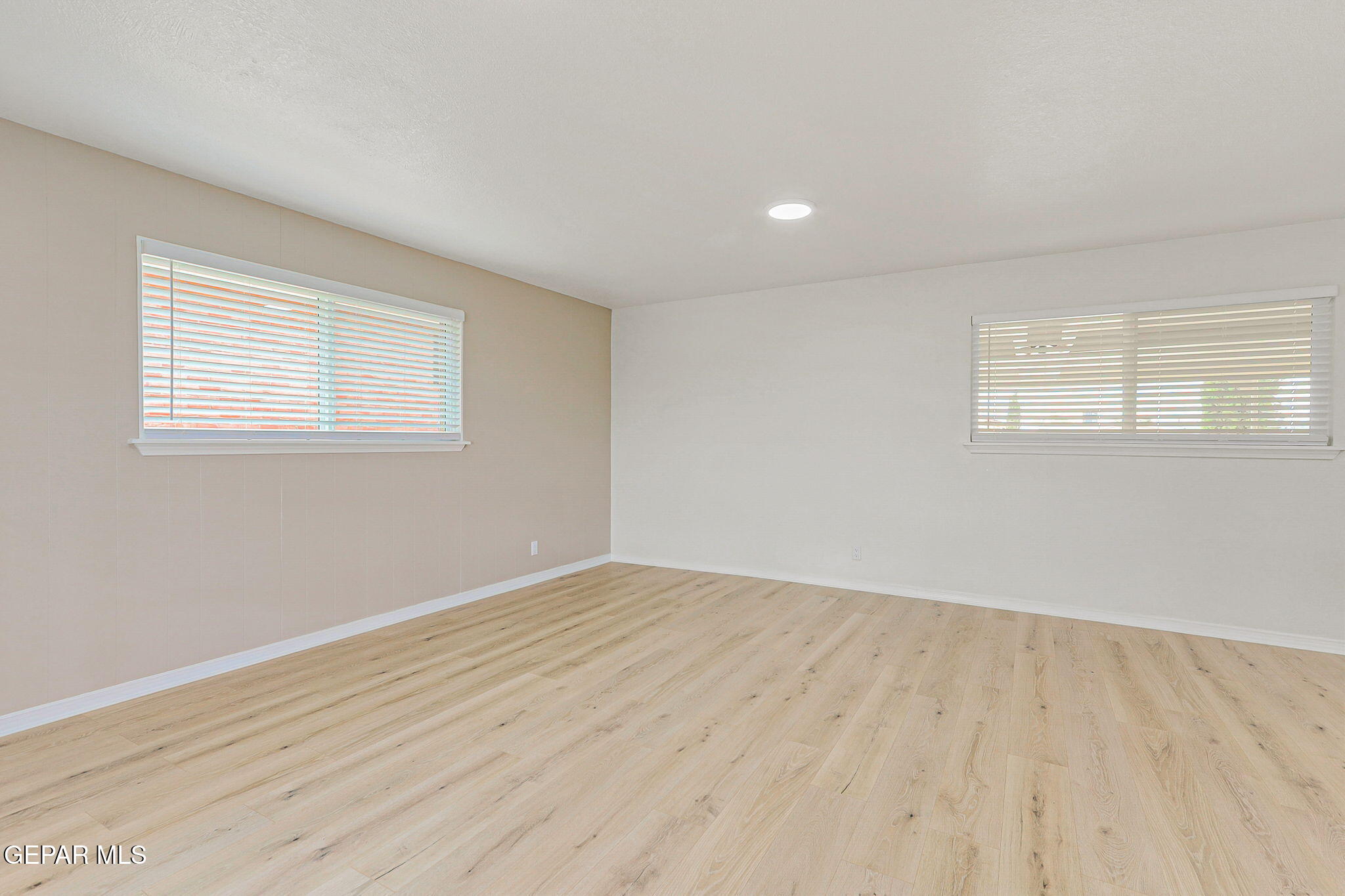 309 Clairemont Road El Paso, TX 79912 - Photo 16 of 40 an empty room with wooden floor and windows