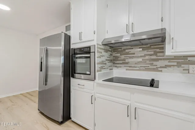 a kitchen with stainless steel appliances granite countertop white cabinets sink and dishwasher