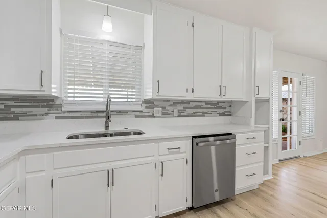 a kitchen with stainless steel appliances granite countertop a refrigerator sink and white cabinets