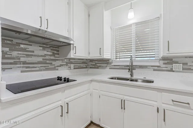 a kitchen with stainless steel appliances white cabinets and wooden floor