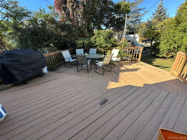 a view of a patio with table and chairs with wooden floor and fence