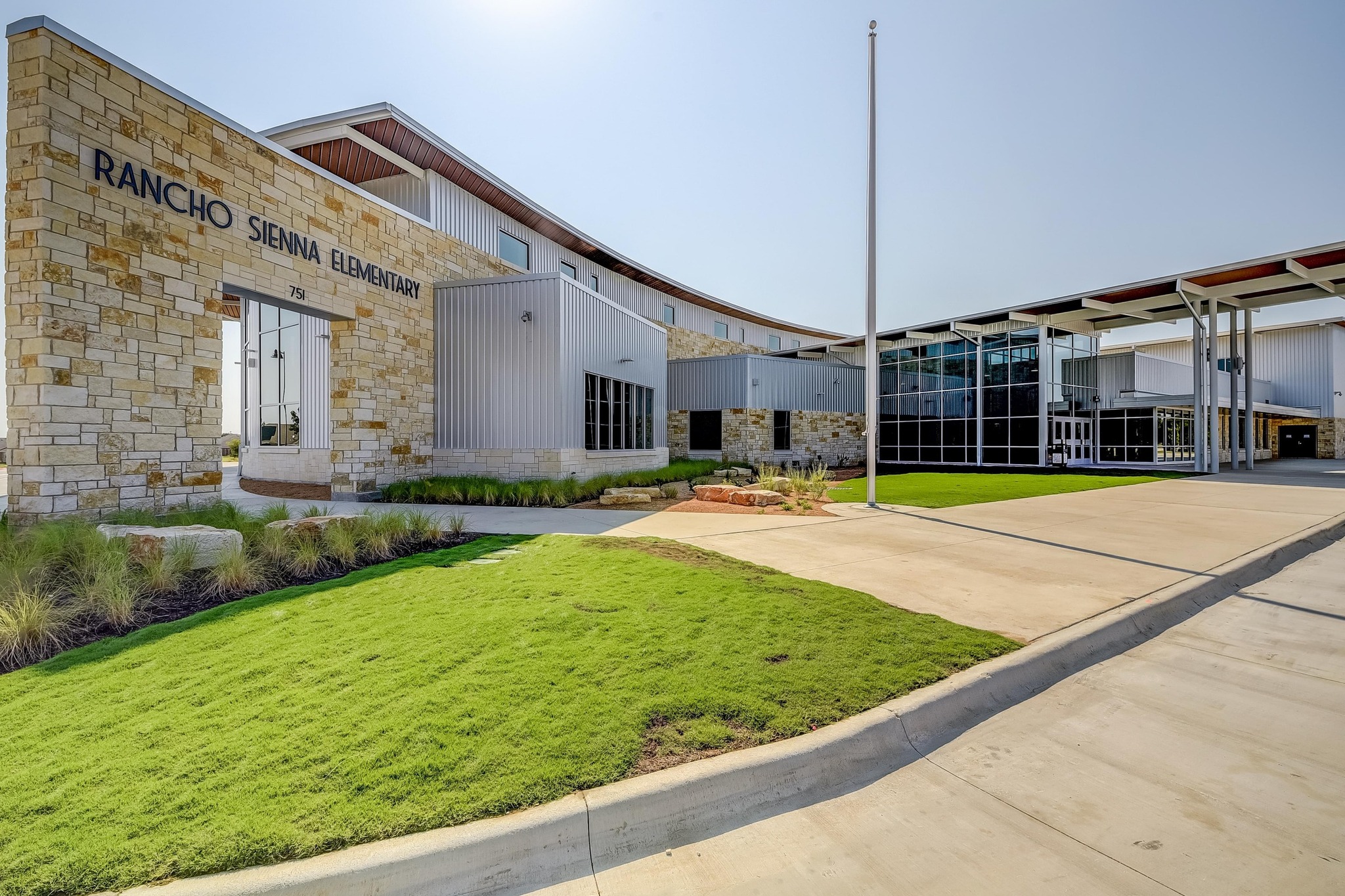 68 Rancho Trail Georgetown, TX 78628 - Photo 27 of 39 A modern facade with natural stone and metal siding presents a welcoming school entrance.