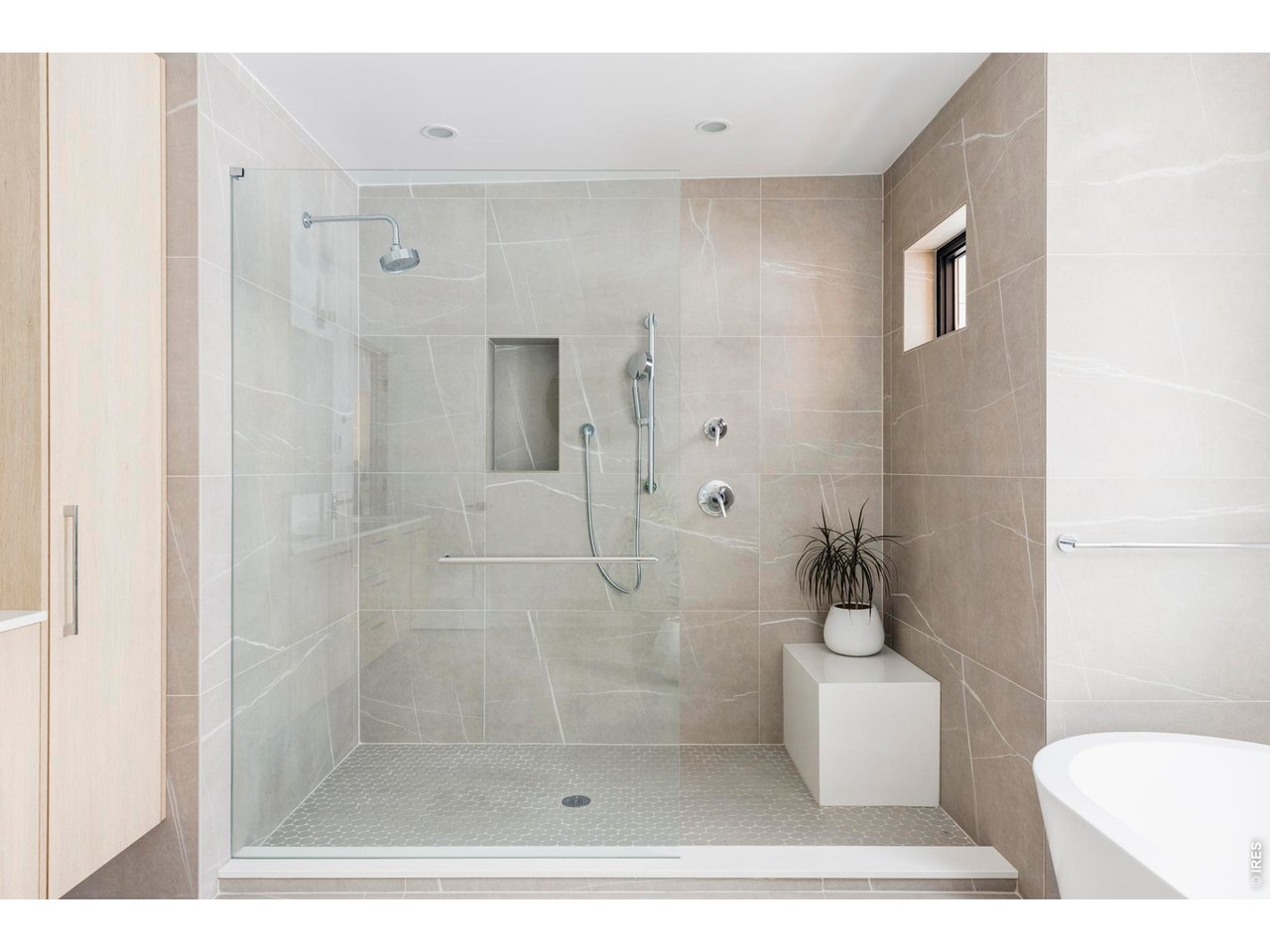 3560 16th Street Boulder, CO 80304 - Photo 21 of 36 The pristine five-piece ensuite bathroom features a walk-in shower with designer tile, freestanding soaking tub, floating wall-mounted dual sinks, and windows that capture magnificent Flatirons views.