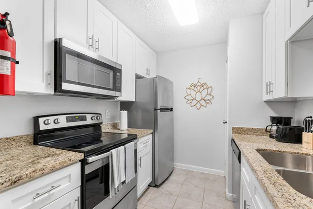 a kitchen with stainless steel appliances granite countertop a stove microwave and refrigerator