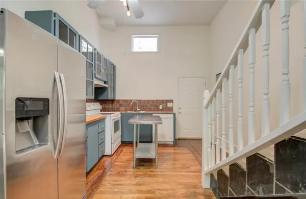 a view of a kitchen with wooden floor and electronic appliances