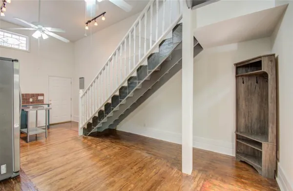 a view of a hallway with wooden floor and staircase