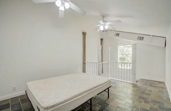 a room with chandelier fan and windows