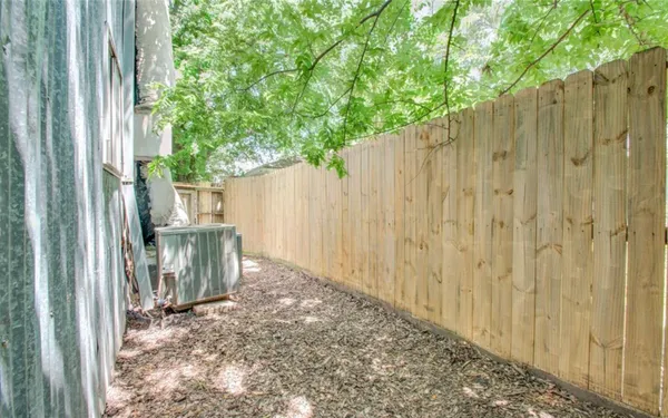 a view of a porch with a tree and wooden fence