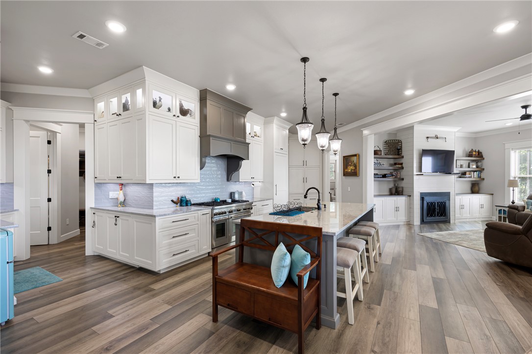 3419 Bailey Loop Road London, AR 72847 - Photo 14 of 60 Expansive open-concept kitchen featuring a large island with seating, pendant lighting, white cabinetry, and stainless steel appliances