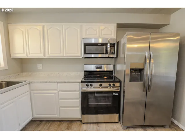 a kitchen with a refrigerator stove and cabinets