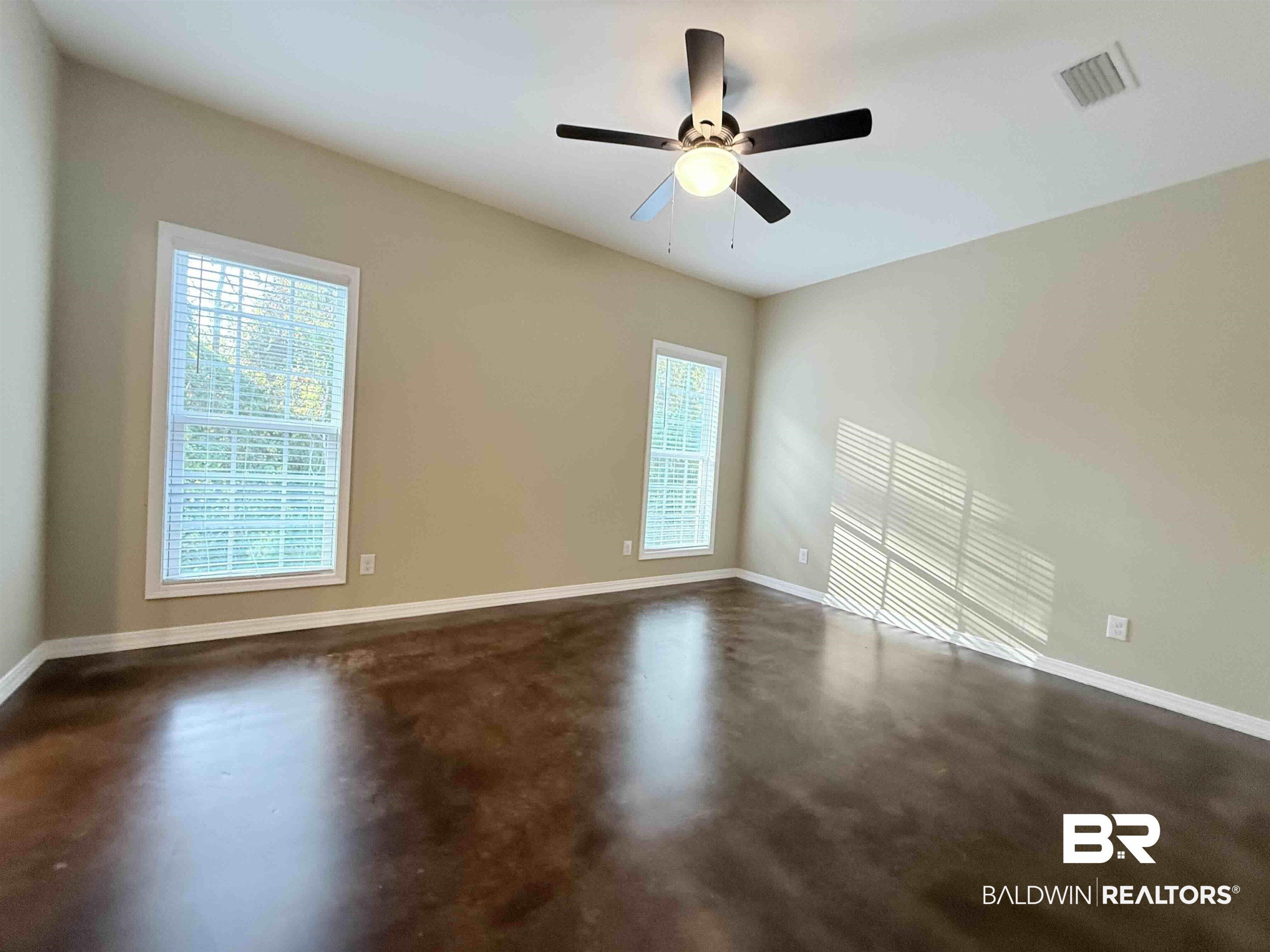 33071 -B Stables Drive, Unit B Daphne, AL 36527 - Photo 9 of 13 Empty room featuring healthy amount of natural light, finished concrete floors, and a ceiling fan