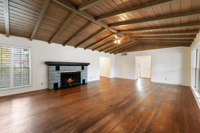 a view of empty room with wooden floor and fireplace