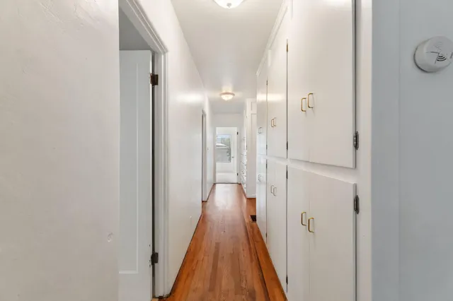 a view of a hallway with wooden floor