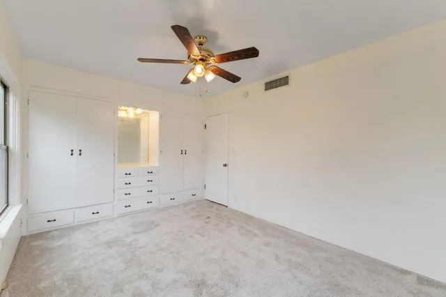 an empty room with closet and windows