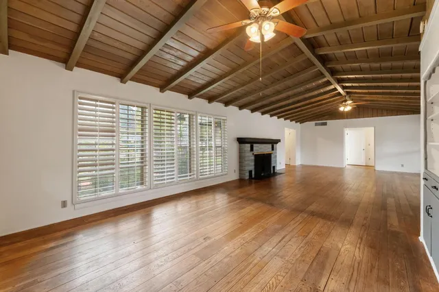 a view of empty room with wooden floor and fireplace