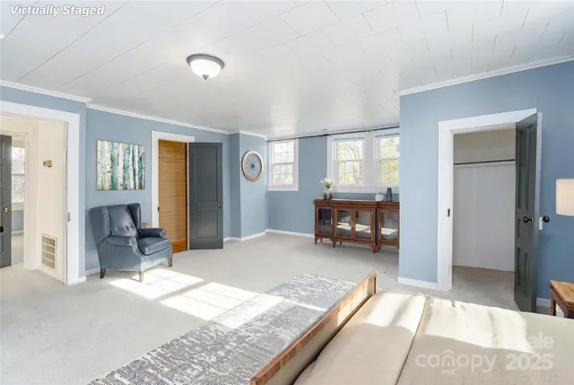 a view of an empty room with window and closet area