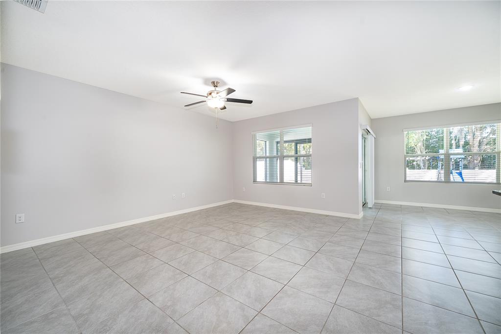 3102 Bethpage Loop Mount Dora, FL 32757 - Photo 14 of 29 an empty room with windows and chandelier fan