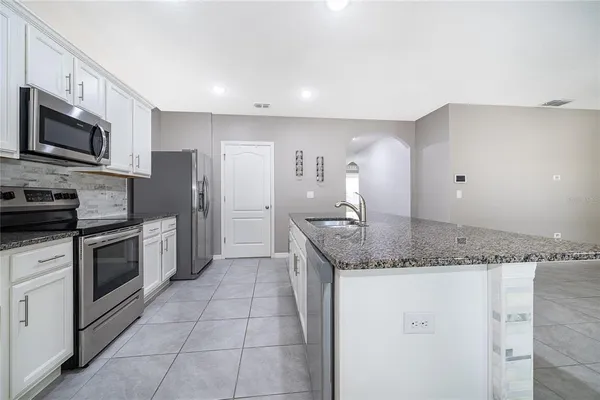 a kitchen with granite countertop a sink and steel stainless steel appliances