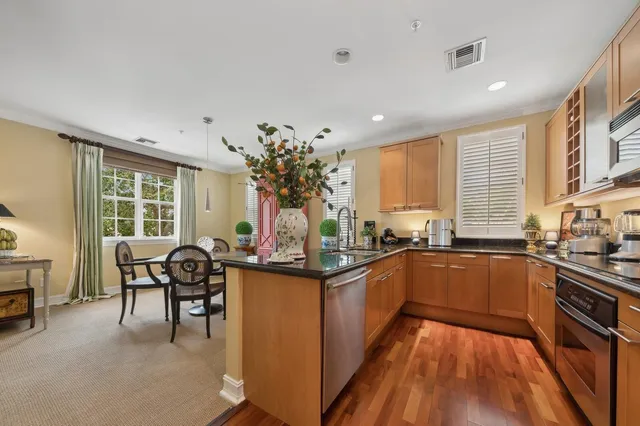 a kitchen with stainless steel appliances granite countertop sink stove top oven and cabinets