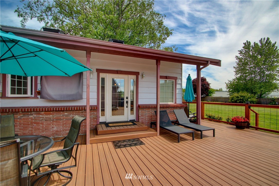 17566 Dunbar Road Mount Vernon, WA 98273 - Photo 24 of 40 a view of a patio with table and chairs under an umbrella with wooden floor