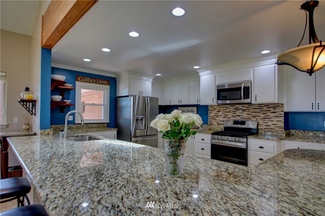 17566 Dunbar Road Mount Vernon, WA 98273 - Photo 6 of 40 a kitchen with stainless steel appliances kitchen island granite countertop a stove and a sink