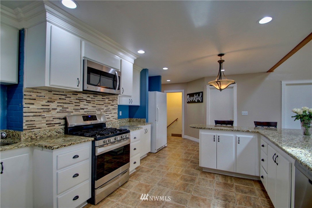17566 Dunbar Road Mount Vernon, WA 98273 - Photo 7 of 40 a large kitchen with stainless steel appliances granite countertop a stove a sink and a microwave