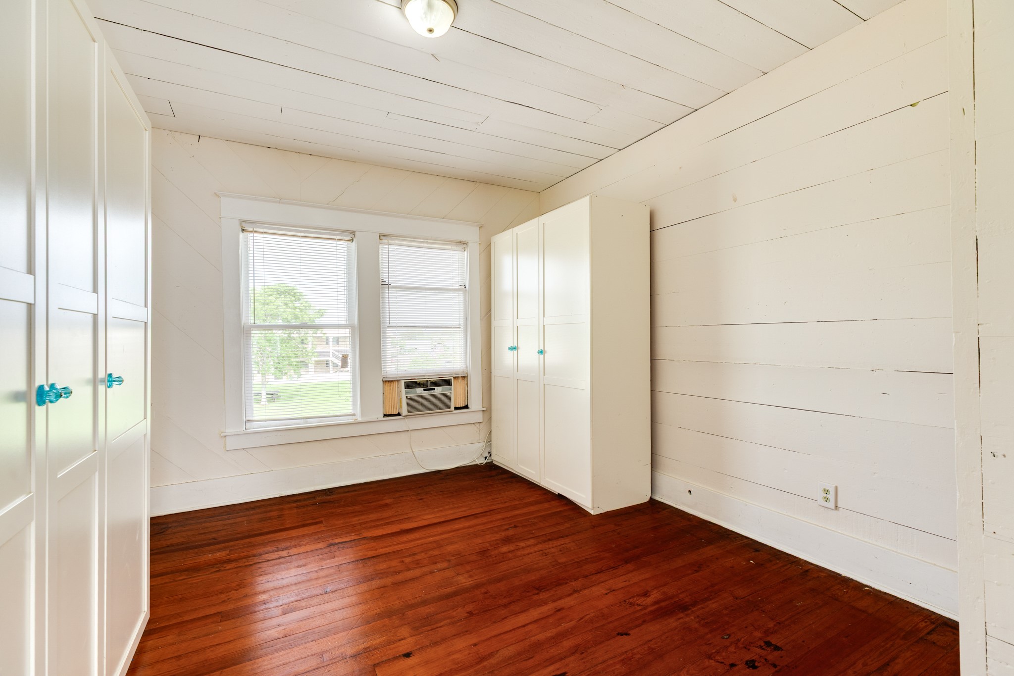 331 West Broad Street Freeport, TX 77541 - Photo 21 of 31 an empty room with wooden floor and windows