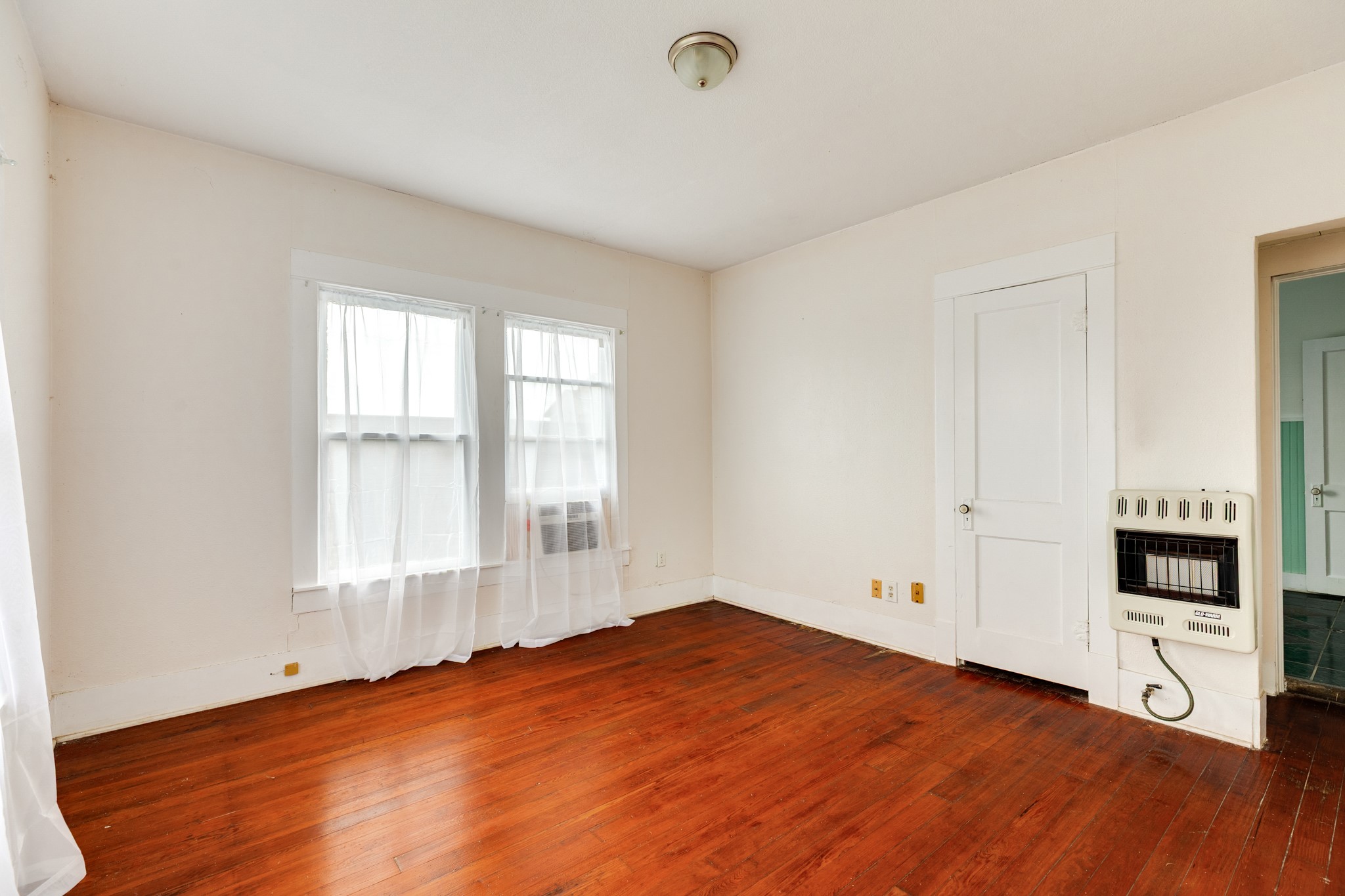 331 West Broad Street Freeport, TX 77541 - Photo 24 of 31 an empty room with wooden floor and windows