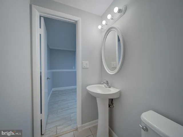 a bathroom with a toilet sink and mirror