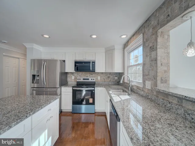 a large kitchen with a stove sink microwave and refrigerator