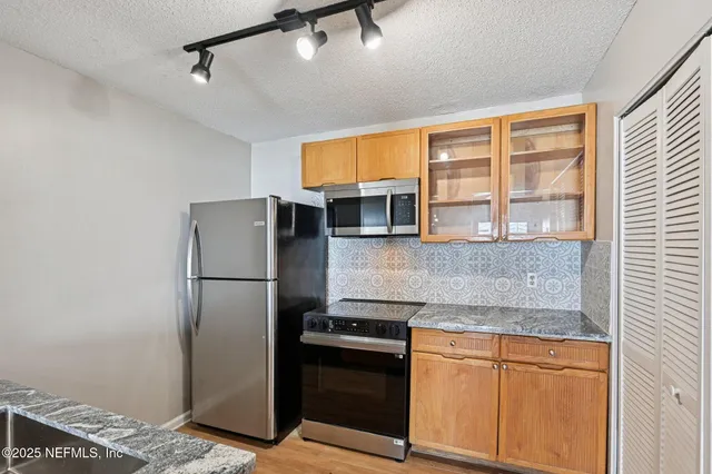 a kitchen with a sink cabinets and wooden floor