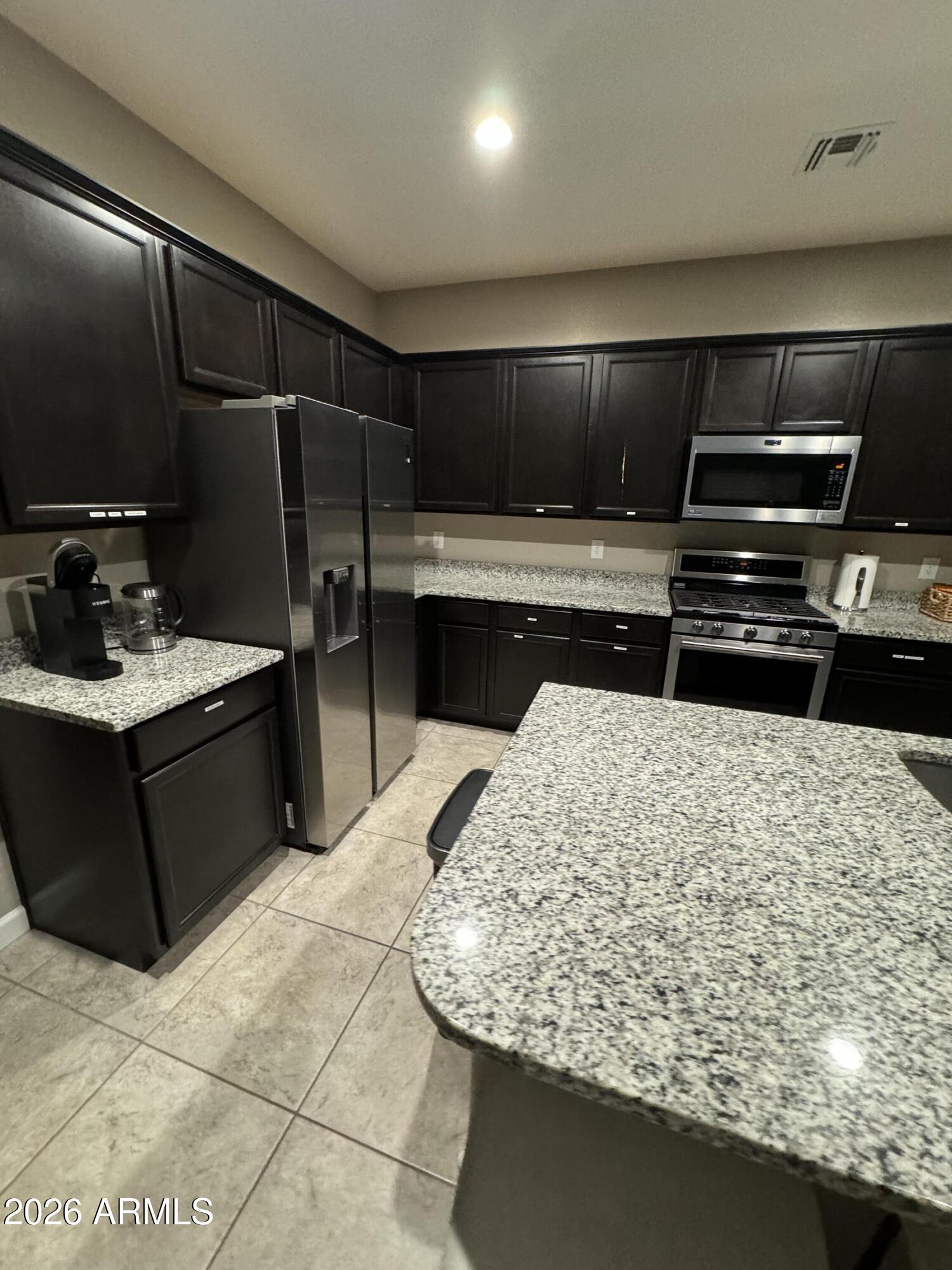 18735 North Ravello Road Maricopa, AZ 85138 - Photo 12 of 50 a kitchen with a sink and a refrigerator