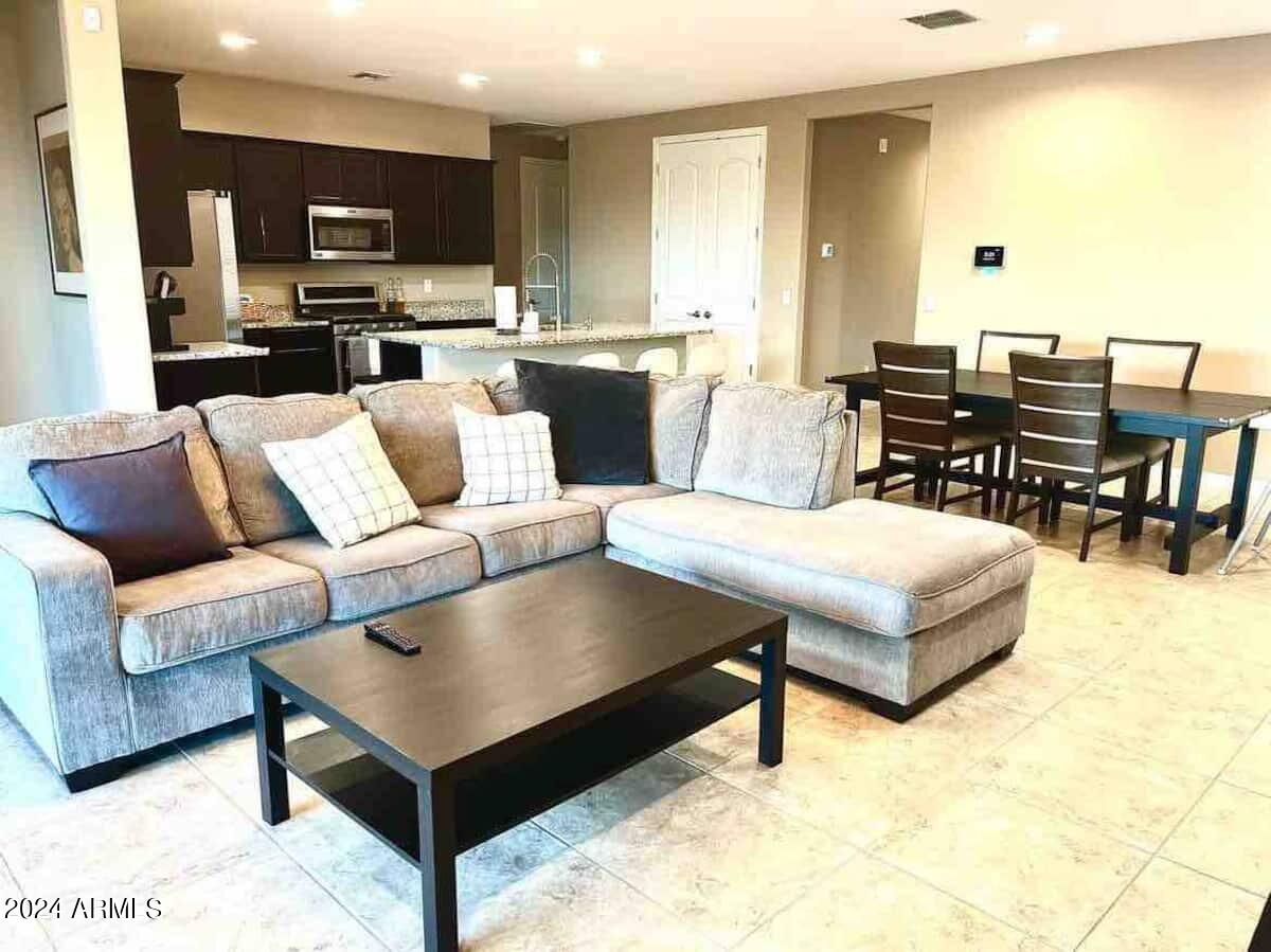 18735 North Ravello Road Maricopa, AZ 85138 - Photo 48 of 50 a living room with couches a coffee table and kitchen view with wooden floor