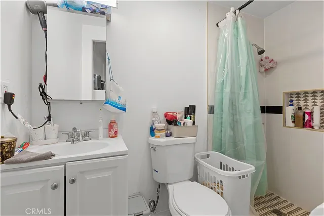 a bathroom with a sink toilet vanity and shower